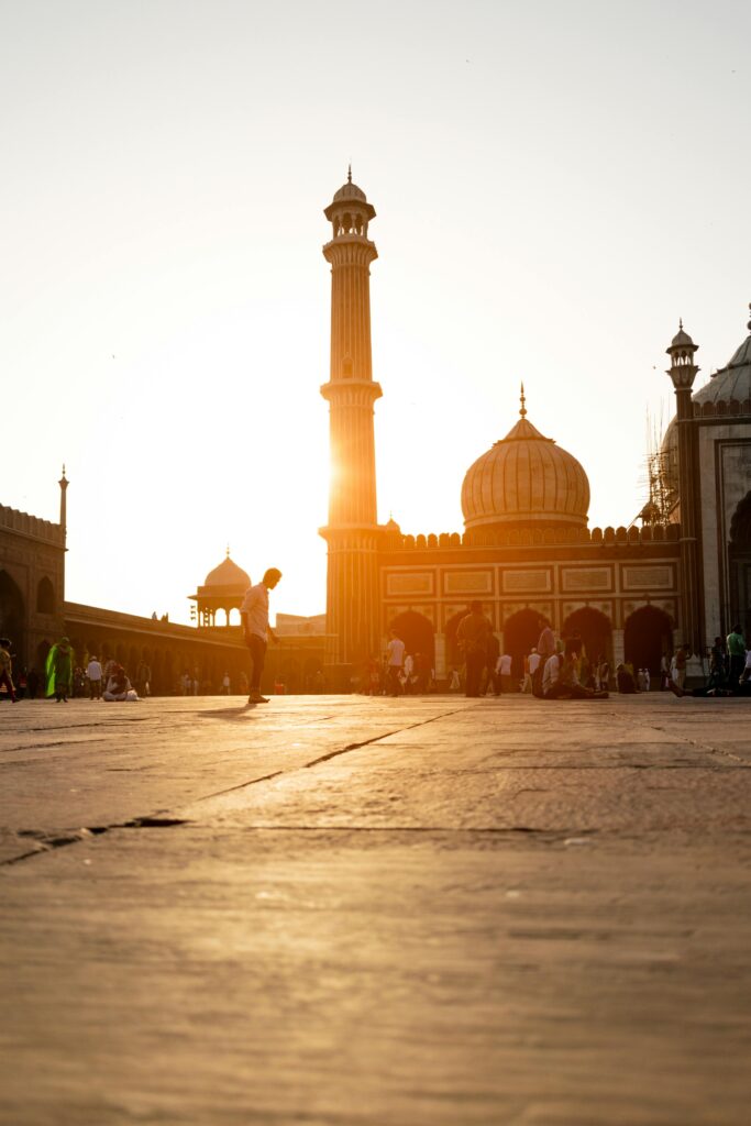 Beautiful evening view of Jama Masjid in New Delhi with people gathering at sunset.